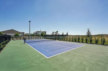 A tennis court with a net and a green surface
